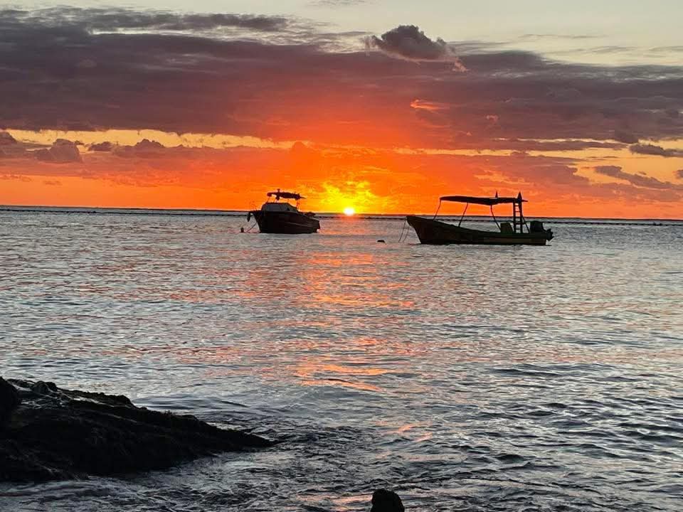 Atardecer sobre el mar con lanchas