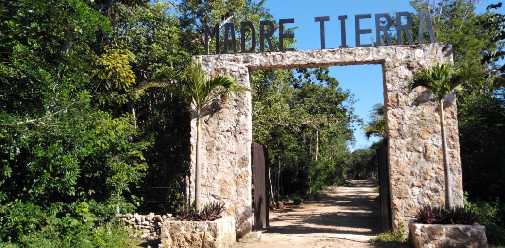Arco de piedra de la entrada con el letrero Madre Tierra