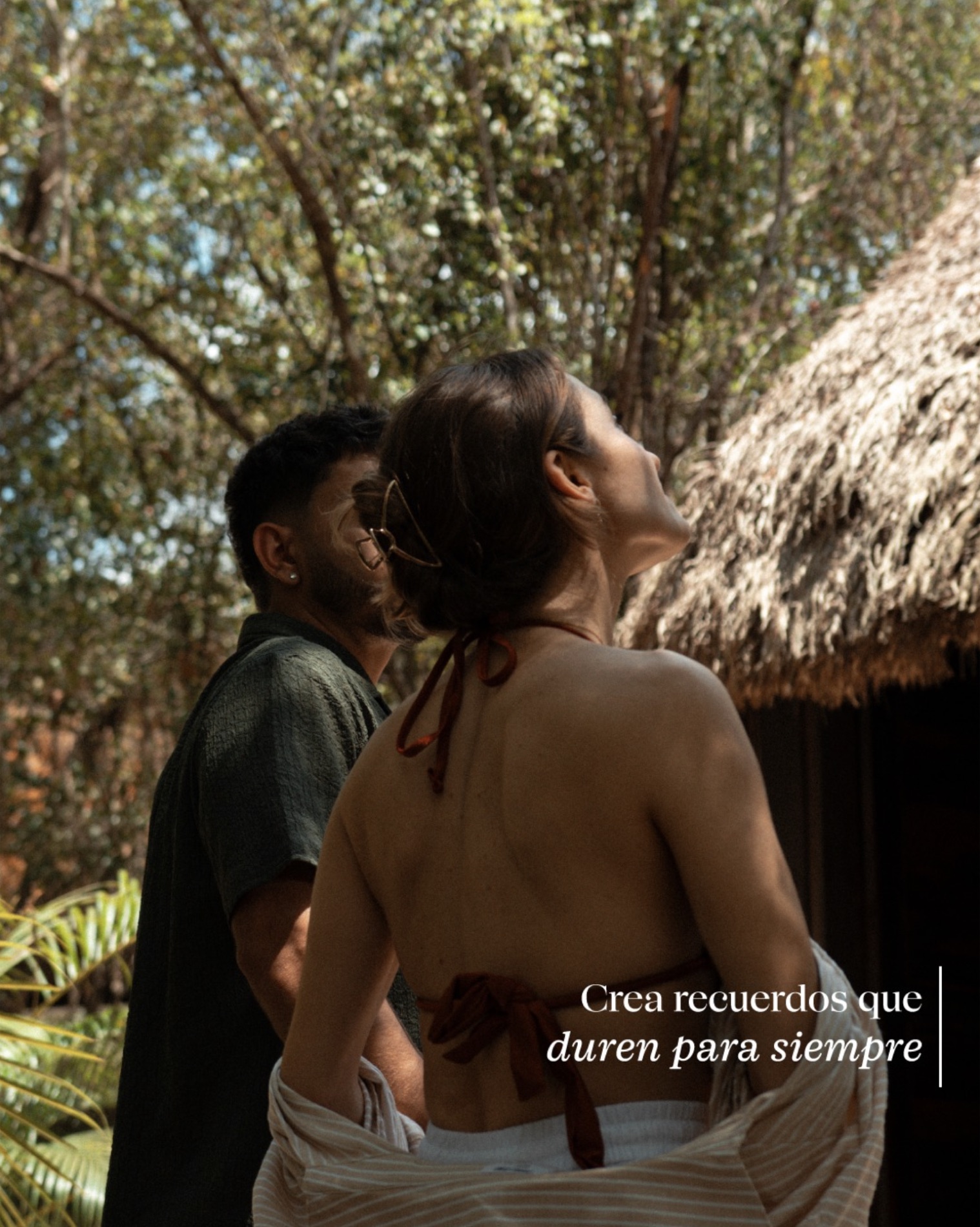Pareja frente a una cabaña en la selva